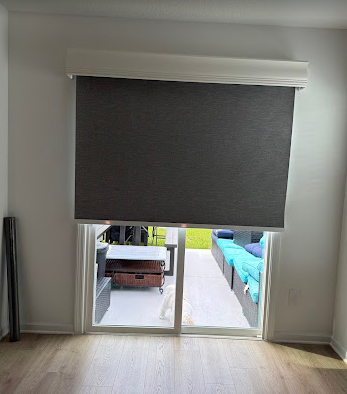 Custom blackout roller shade installed over a sliding glass door in a Nocatee home